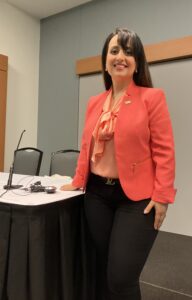 Dr. Attar in orange jacket near the podium at her AOA talk on AI in optometry