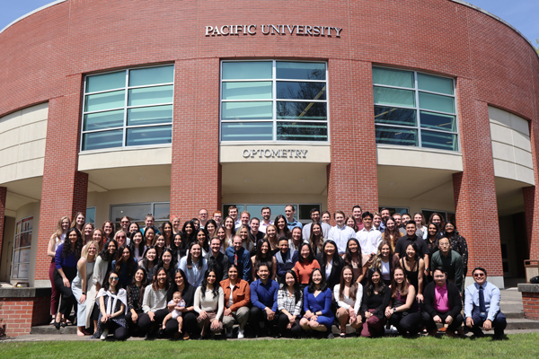 PCO class of 2024, poses in front of the optometry building for more west optometry grads
